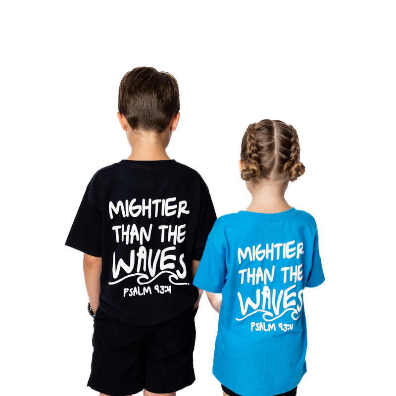 Two children wearing t-shirts with 'Mightier Than The Waves' text on a white background